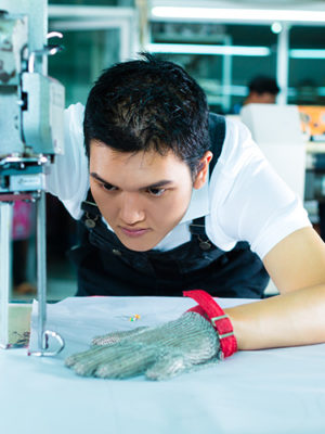 Arbeiter kontrolliert eine Naht in einer Fabrik in China